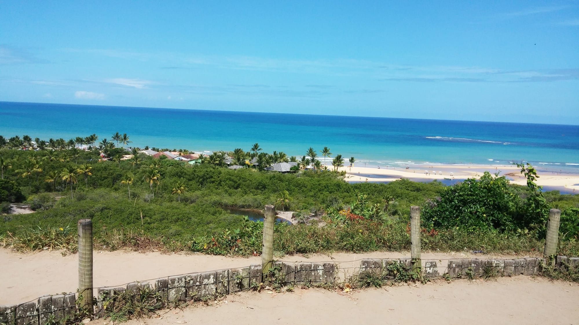 Mar turquesa e coqueiros vistos da ponta do Quadrado de Trancoso