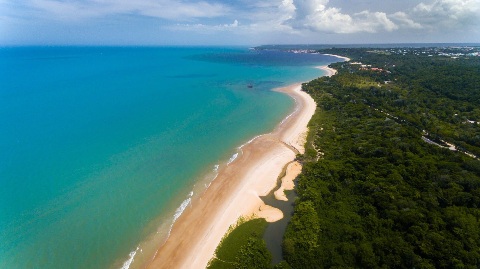 Vista aérea da Praia de Mundaí, em Porto Seguro, com mar turquesa e areia clara
